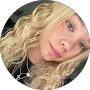 Here's an alt text option following all guidelines:
Blonde woman with wavy hair poses for a close-up photo.